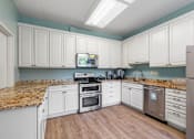 Thumbnail 5 of 25 - a kitchen with white cabinets and marble counter tops