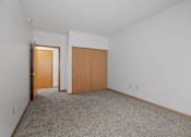 Thumbnail 9 of 27 - a bedroom with carpet and a door to a closet