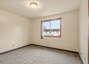 Thumbnail 13 of 23 - A room with a window and carpeted floor.