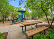 Thumbnail 32 of 57 - a playground with a slide and benches in a park