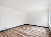 Thumbnail 38 of 40 - an empty room with wood flooring and a window