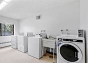 Thumbnail 20 of 25 - an empty laundry room with washing machines and other appliances