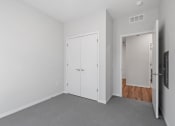 Thumbnail 15 of 45 - a bedroom with white walls and a door to a closet