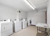 Thumbnail 13 of 25 - a laundry room with washers and dryers and a table