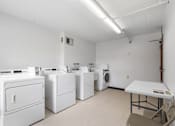 Thumbnail 19 of 25 - a laundry room with washers and dryers and a table