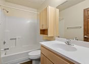 Thumbnail 10 of 23 - A white sink is in a bathroom with a white tub and toilet.