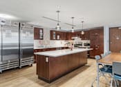 Thumbnail 24 of 55 - a kitchen with wooden cabinets and stainless steel appliances