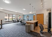 Thumbnail 16 of 35 - a conference room with a table and chairs and a refrigerator