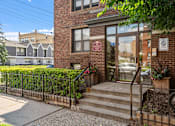 Thumbnail 9 of 25 - the front of a brick building with stairs and a glass door