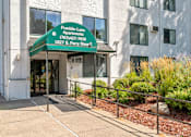 Thumbnail 2 of 23 - the front entrance of a building with a green sign that reads