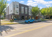 Thumbnail 42 of 52 - an apartment building with two cars parked in front of it