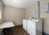 Thumbnail 28 of 57 - a laundry room with two washing machines and a table