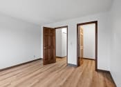 Thumbnail 12 of 25 - a living room with wood floors and white walls