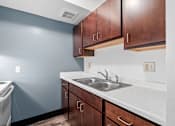 Thumbnail 39 of 40 - a kitchen with wooden cabinets and a sink and a stove