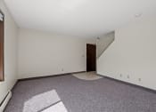 Thumbnail 27 of 57 - a living room with carpet and a door to a staircase