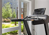 Thumbnail 23 of 53 - a treadmill in front of a window with a laptop on it