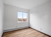 Thumbnail 5 of 25 - the living room of an empty apartment with wood flooring and a window