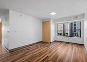 Thumbnail 11 of 26 - an empty living room with wood floors and a window