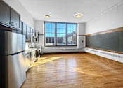 Thumbnail 2 of 24 - an empty kitchen with wood floors and a window