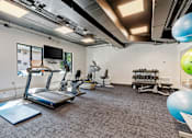 Thumbnail 35 of 55 - a gym with treadmills and other exercise equipment and a tv