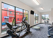 Thumbnail 15 of 35 - a gym with exercise equipment and large windows