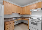 Thumbnail 4 of 43 - a kitchen with white appliances and wooden cabinets