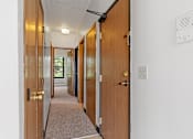Thumbnail 23 of 67 - an empty hallway with wooden doors and a carpeted floor