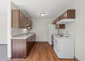 Thumbnail 22 of 57 - an empty kitchen with white appliances and wood floors