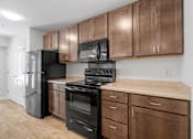 Thumbnail 3 of 53 - a kitchen with black appliances and wooden cabinets