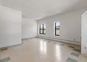Thumbnail 21 of 67 - a spacious living room with white walls and tile floors