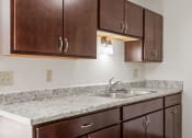 Thumbnail 3 of 57 - a kitchen with a sink and wooden cabinets