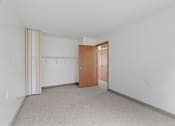 Thumbnail 42 of 43 - a bedroom with a door to a closet and a carpeted floor
