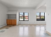 Thumbnail 20 of 67 - an empty living room with three windows and a tile floor