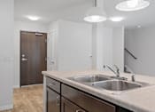 Thumbnail 4 of 53 - a kitchen with a sink and a door to a hallway