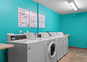 Thumbnail 25 of 35 - a laundry room with washers and dryers and a row of washing machines