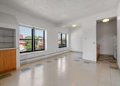 Thumbnail 19 of 67 - an empty living room and kitchen with large windows and tiled floors