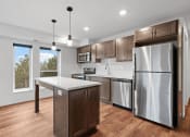 Thumbnail 18 of 36 - An apartment kitchen with stainless steel appliances and an island.