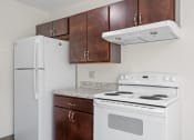 Thumbnail 19 of 57 - a kitchen with white appliances and wooden cabinets and a refrigerator
