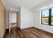 Thumbnail 12 of 26 - an empty room with wooden floors and a large window