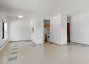 Thumbnail 18 of 67 - the living room and kitchen of an empty apartment with white walls and tile flooring