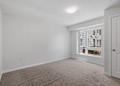Thumbnail 8 of 53 - a bedroom with a large window and white walls