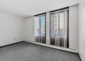 Thumbnail 27 of 51 - an empty living room with large windows and gray carpet