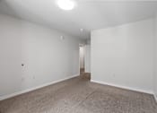Thumbnail 21 of 53 - a bedroom with white walls and carpeting and a doorway to a closet
