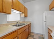 Thumbnail 63 of 67 - a kitchen with wooden cabinets and a sink and a refrigerator