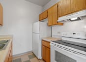 Thumbnail 62 of 67 - a kitchen with white appliances and wooden cabinets