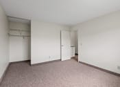 Thumbnail 16 of 57 - a bedroom with white walls and carpet and a door to a closet