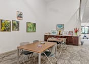 Thumbnail 47 of 55 - a dining room with tables and chairs and paintings on the wall