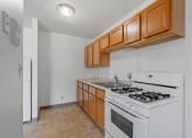 Thumbnail 37 of 51 - an empty kitchen with white appliances and wooden cabinets