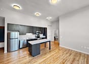 Thumbnail 13 of 24 - a kitchen with a island and a stainless steel refrigerator