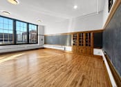 Thumbnail 4 of 24 - an empty room with wood floors and a chalkboard on the wall